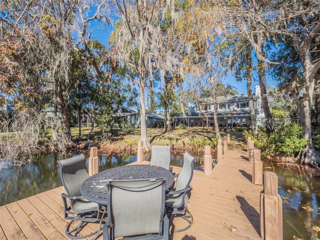 1444 Pelican Bay Trail Winter Park, FL 32792 - Photo 56 of 57 a view of a patio with dining table and chairs with wooden fence and plants