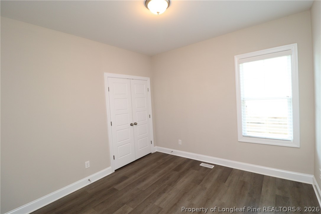 8424 Rhodes Road Apex, NC 27539 - Photo 23 of 31 an empty room with wooden floor and windows