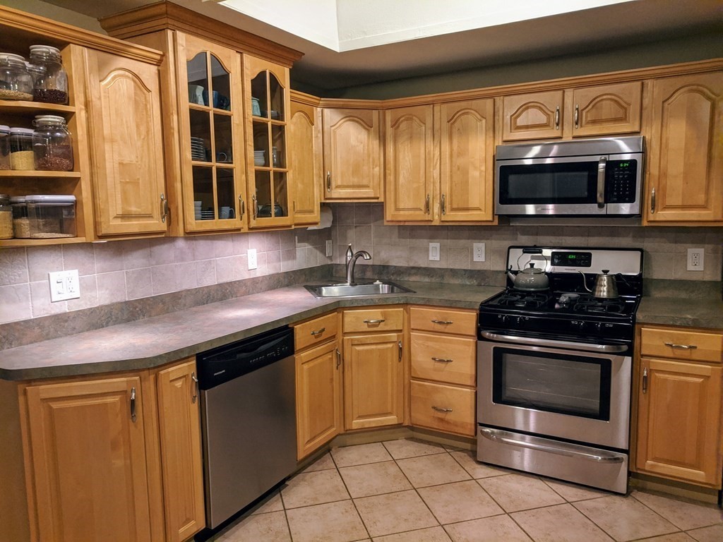 92 Deerfield Road Sharon, MA 02067 - Photo 3 of 18 a kitchen with stainless steel appliances granite countertop a stove a sink and a microwave