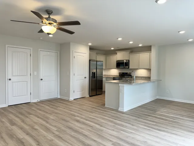 a view of kitchen with granite countertop cabinets and refrigerator