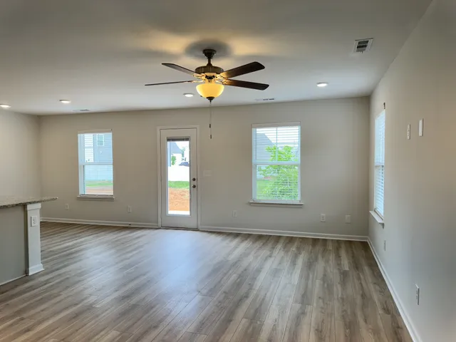 a view of empty room with wooden floor and window