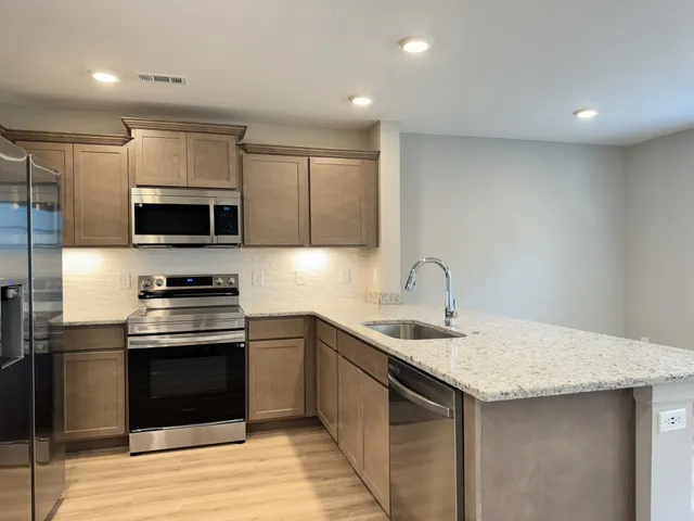 a kitchen with a sink and steel appliances