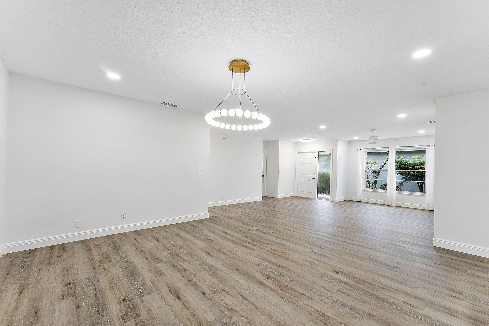 9180 Pine Springs Drive Boca Raton, FL 33428 - Photo 6 of 29 a view of an empty room with window and wooden floor