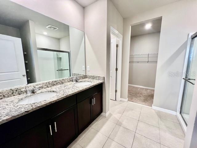 1251 McNeal Road Spring Hill, FL 34608 - Photo 21 of 46 a bathroom with a granite countertop sink a mirror and a shower