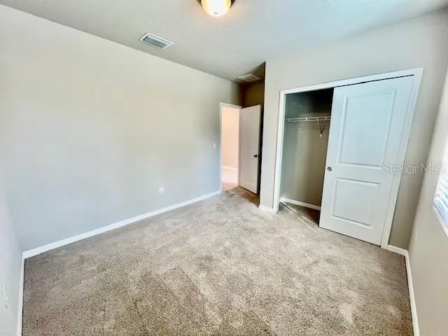 an empty room with closet and windows