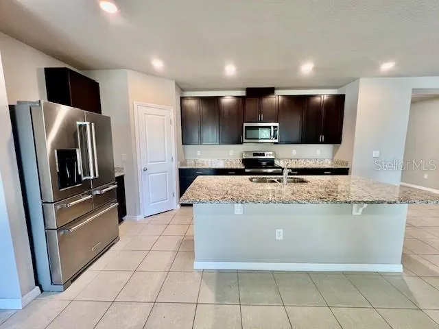 a kitchen with stainless steel appliances granite countertop a refrigerator and a stove