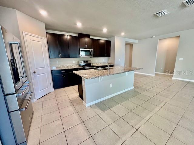 1251 McNeal Road Spring Hill, FL 34608 - Photo 8 of 46 a large kitchen with stainless steel appliances granite countertop a sink and a stove top oven