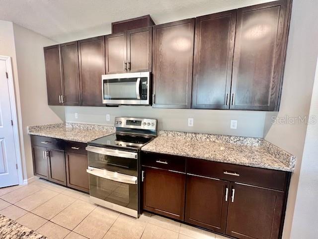 1251 McNeal Road Spring Hill, FL 34608 - Photo 9 of 46 a kitchen with granite countertop wooden cabinets and stainless steel appliances