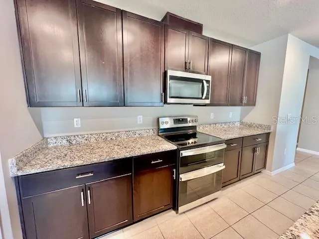 a kitchen with granite countertop stainless steel appliances and cabinets