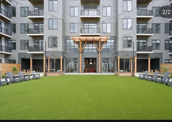 a front view of an apartment building with a garden