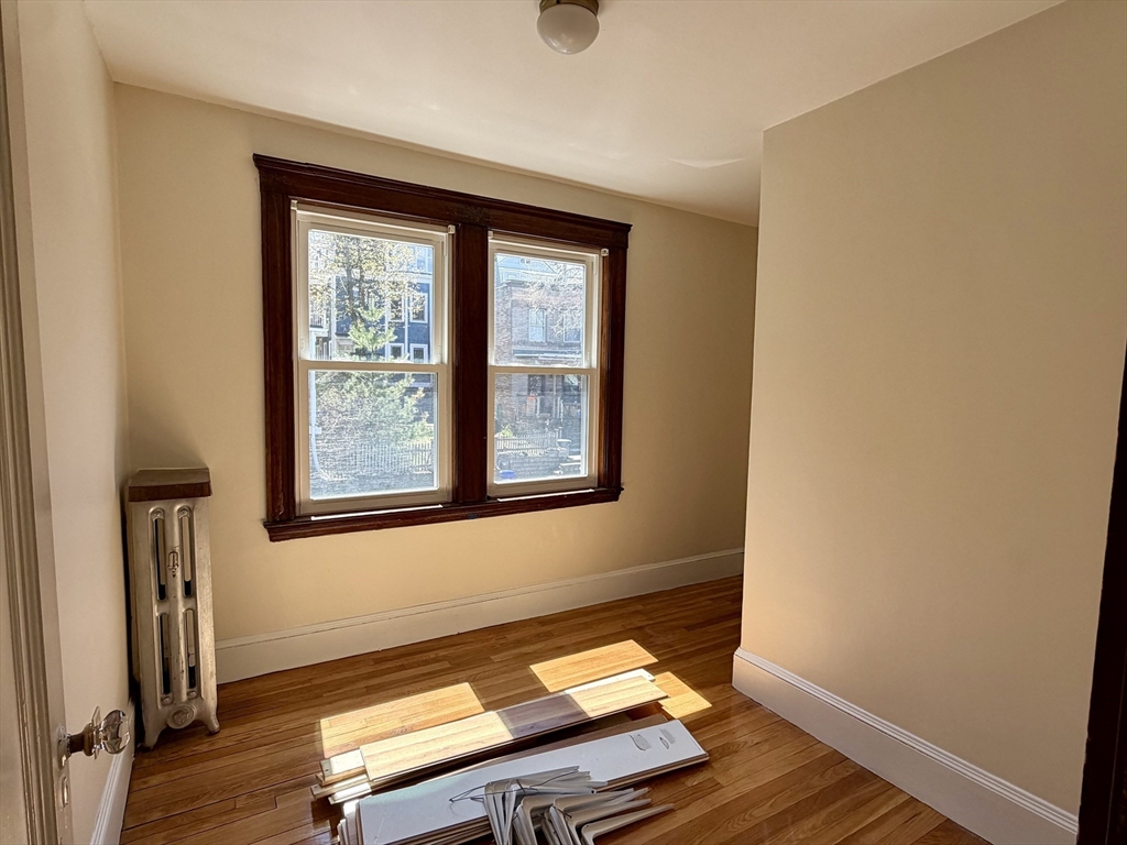 157 Hillside Street, Unit 2 Boston, MA 02120 - Photo 12 of 17 an empty room with wooden floor and windows