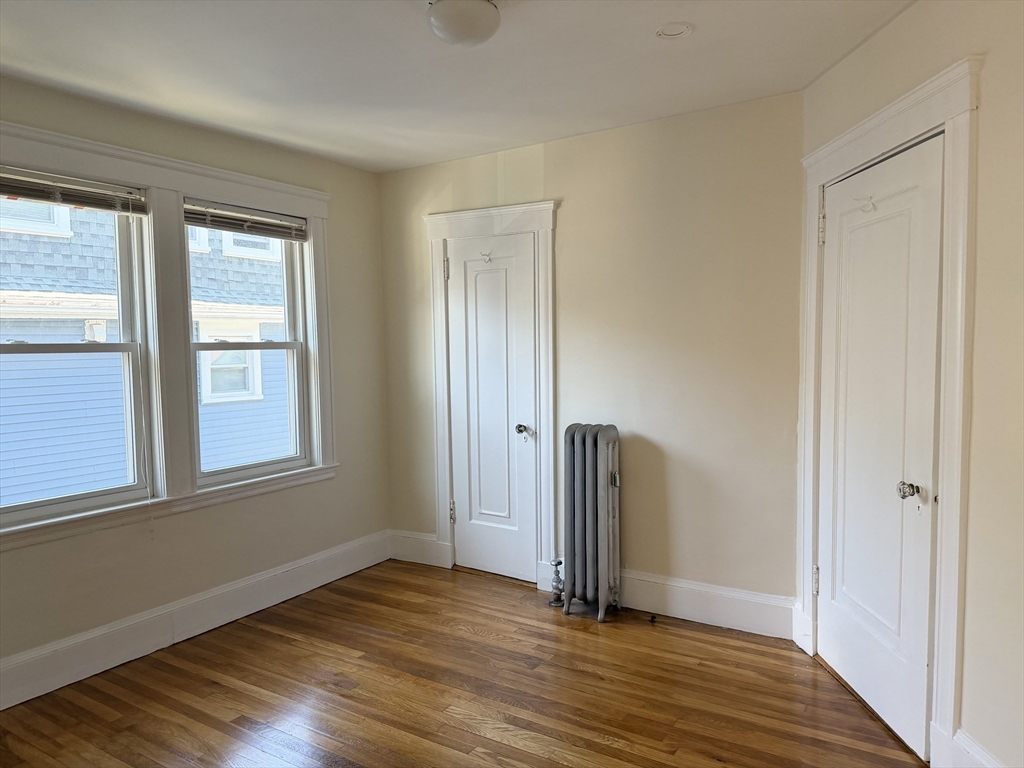 157 Hillside Street, Unit 2 Boston, MA 02120 - Photo 7 of 17 an empty room with wooden floor and windows