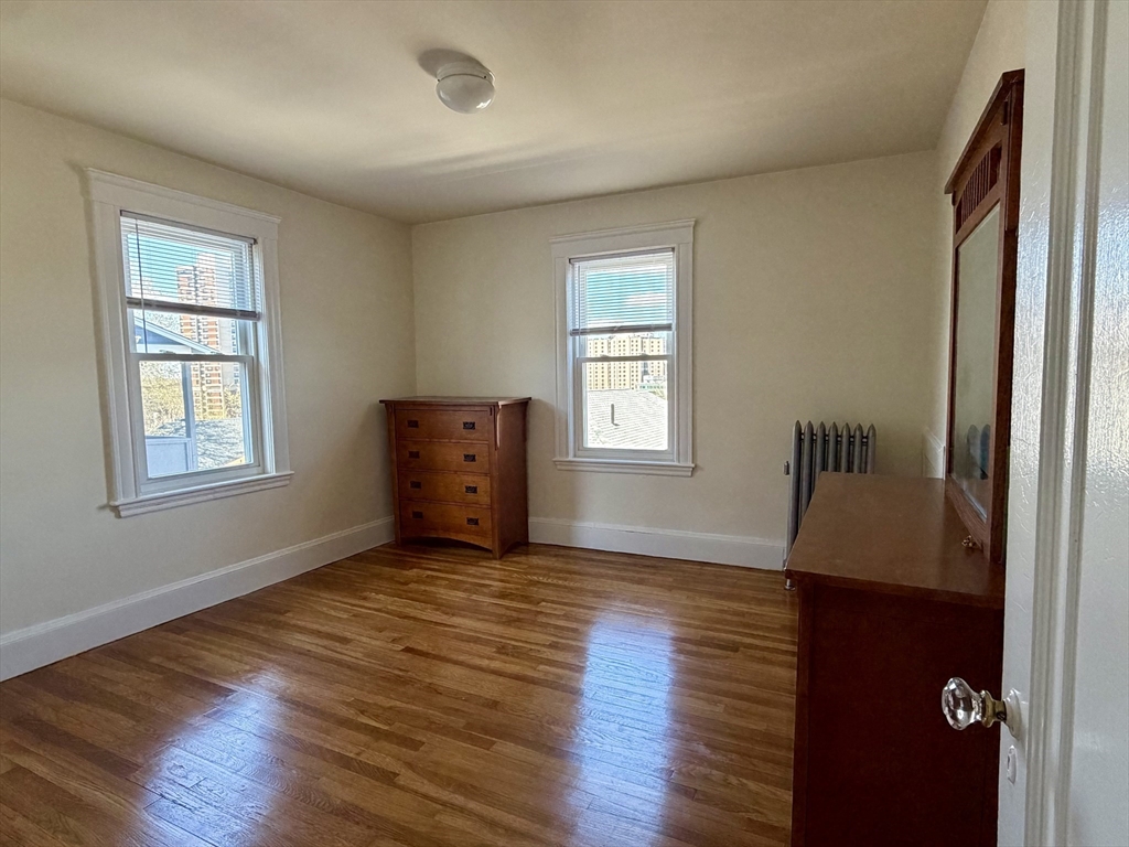 157 Hillside Street, Unit 2 Boston, MA 02120 - Photo 10 of 17 a view of an empty room with a window and wooden floor