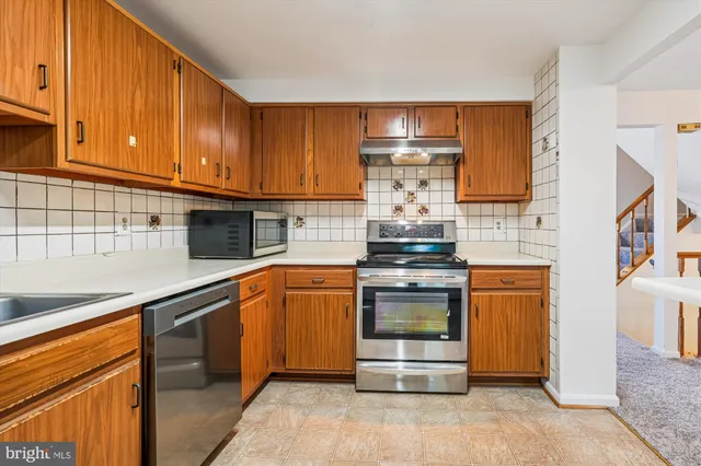 a kitchen with stainless steel appliances granite countertop a stove and a sink