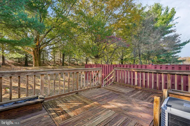 a view of a backyard with wooden fence and large trees