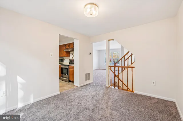 an empty room with staircase and a chandelier