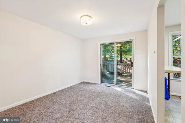 an empty room with floor to ceiling window and an outdoor view