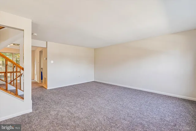 a view of staircase with railing and a rug