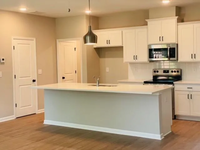 a kitchen with stainless steel appliances granite countertop a sink a stove and a refrigerator