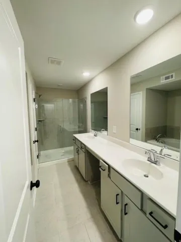 a bathroom with a granite countertop sink mirror and shower