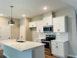 2326 Portrush Way Southeast Atlanta, GA 30339 - Photo 8 of 11 a kitchen with stainless steel appliances a stove sink microwave and cabinets