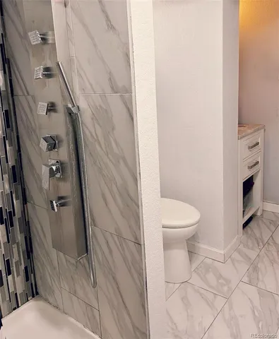 a bathroom with a toilet and a shower