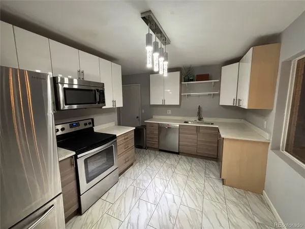 a kitchen with stainless steel appliances a refrigerator sink and microwave