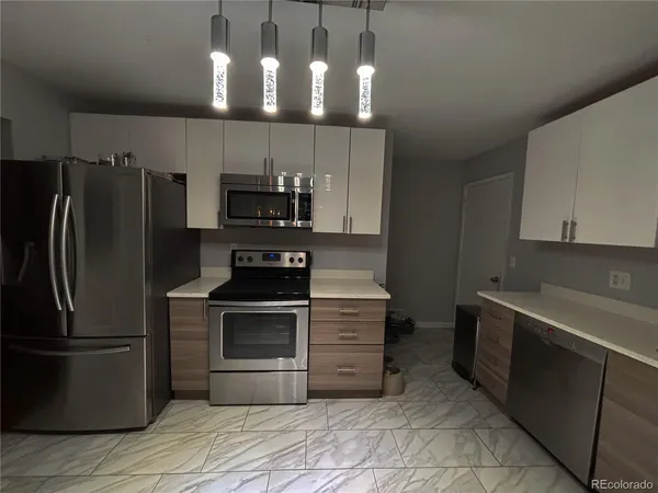 a kitchen with stainless steel appliances granite countertop a refrigerator and a stove