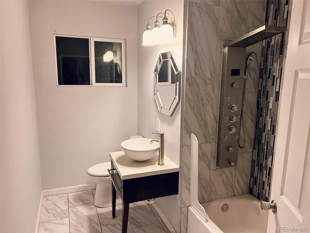 a bathroom with a sink toilet and shower