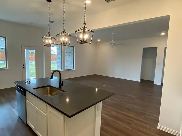 a room with wooden floor and potted plant