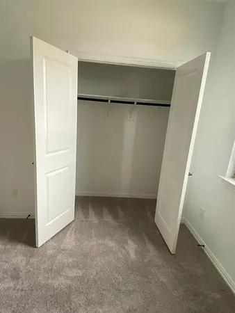 a view of a kitchen with a stove wooden cabinet a refrigerator and windows