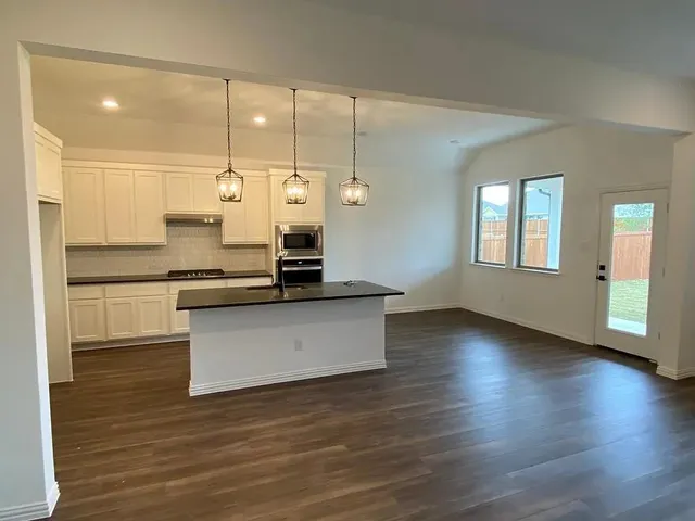 a kitchen with a refrigerator and white cabinets