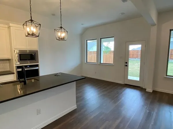 a kitchen with wooden floor and chandelier