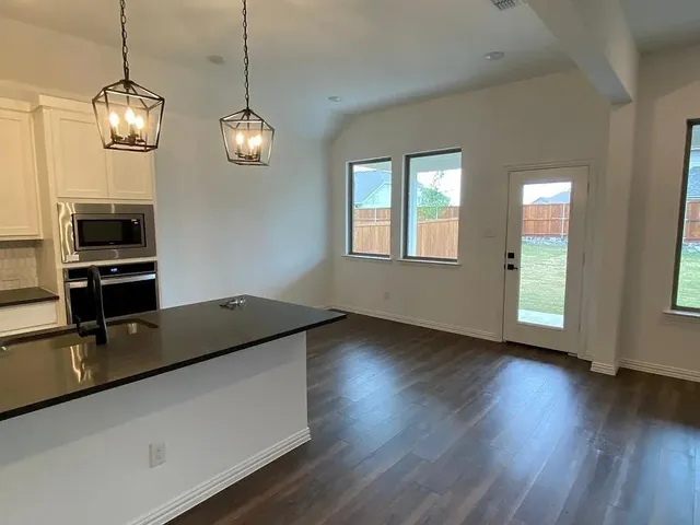 a kitchen with wooden floor and chandelier