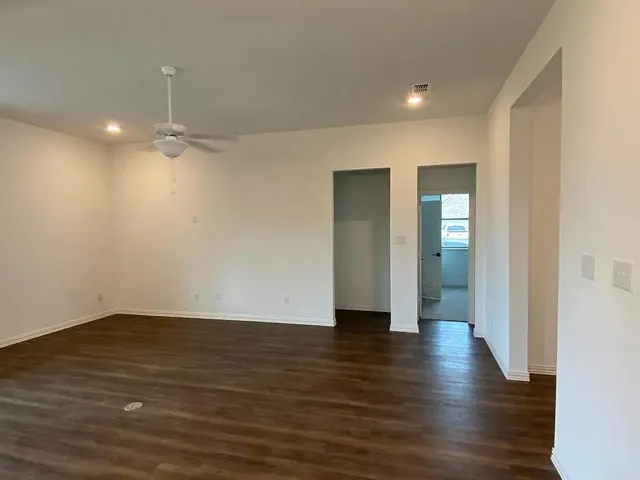 a view of empty room with wooden floor
