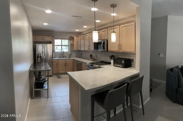 a kitchen with kitchen island a sink stove and refrigerator