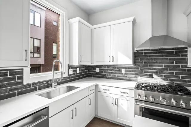 a kitchen with a sink stove top oven and cabinets