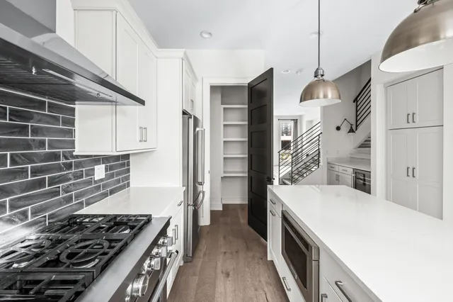 a kitchen with a stove and a wooden floor