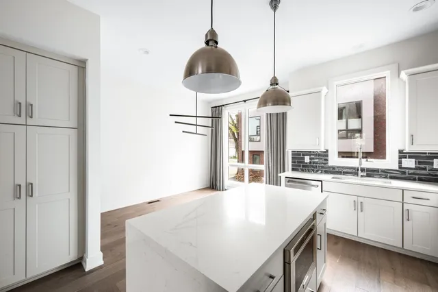 a kitchen with a stove a sink and a chandelier