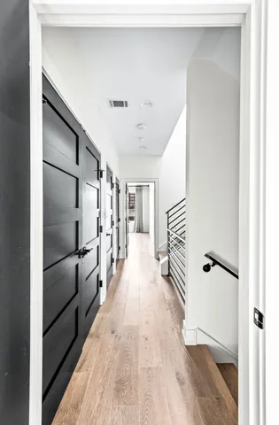 a view of hallway with stairs and wooden floor