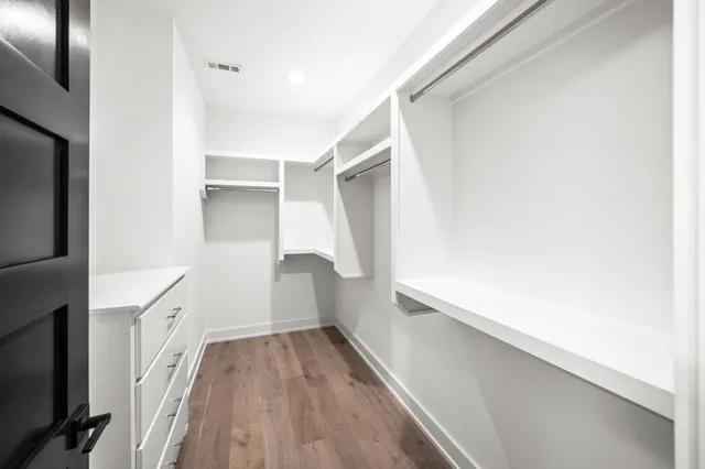 a view of walk in closet with empty racks