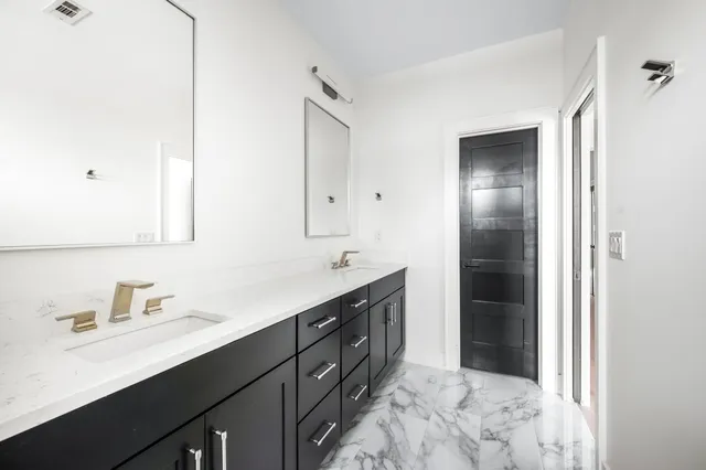 a spacious bathroom with a double vanity sink a and mirror