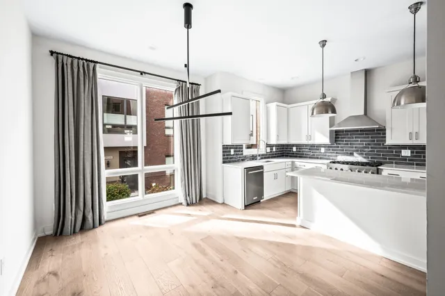 a kitchen with stainless steel appliances kitchen island granite countertop a refrigerator a stove and a sink