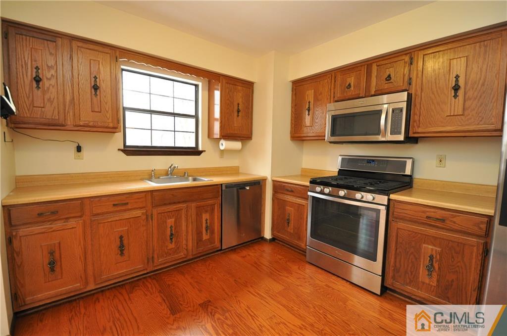449 Cottrell Road Old Bridge, NJ 08857 - Photo 5 of 17 a kitchen with stainless steel appliances granite countertop a stove a sink and a microwave