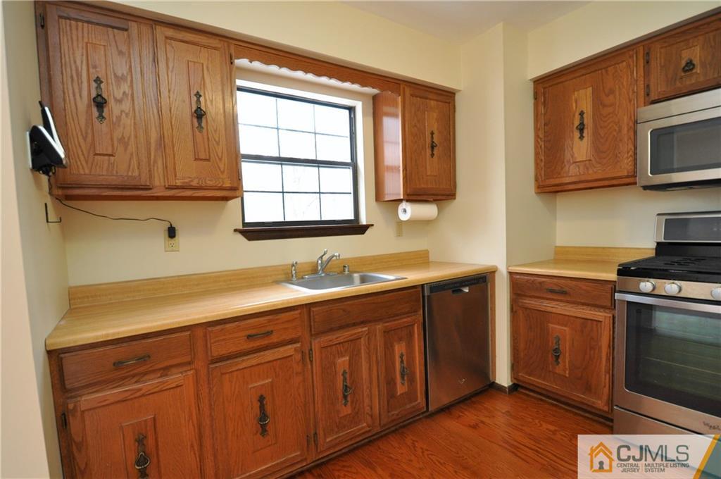 449 Cottrell Road Old Bridge, NJ 08857 - Photo 7 of 17 a kitchen with stainless steel appliances granite countertop a sink a stove a microwave and cabinets
