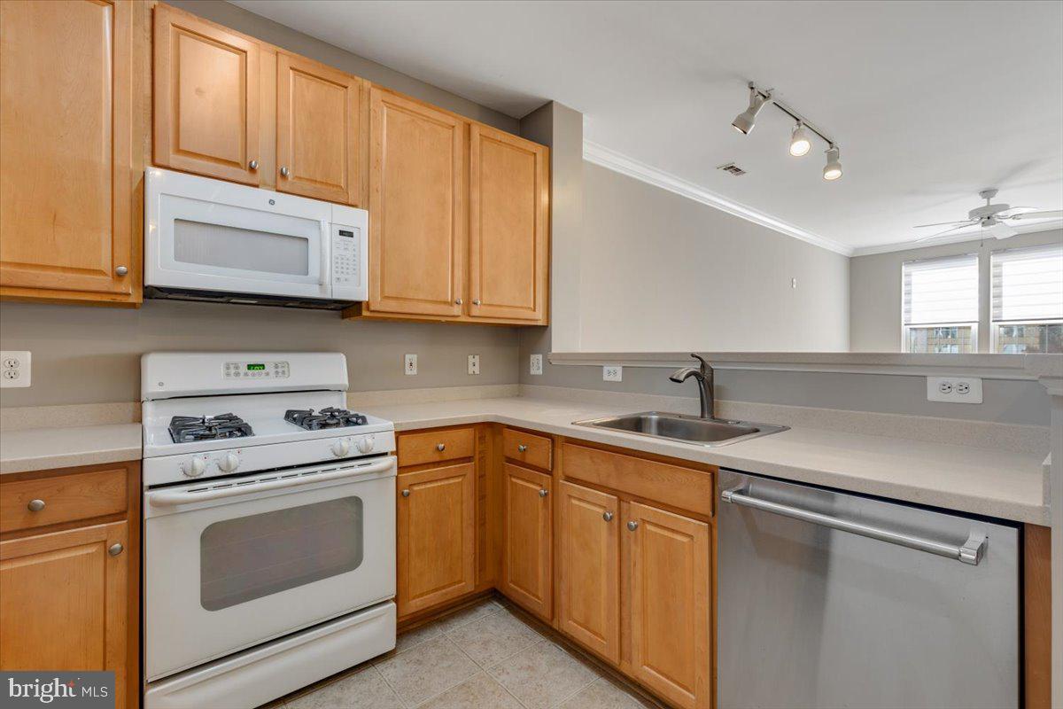 12001 Market Street, Unit 257 Reston, VA 20190 - Photo 4 of 33 a kitchen with cabinets appliances a sink and a counter space