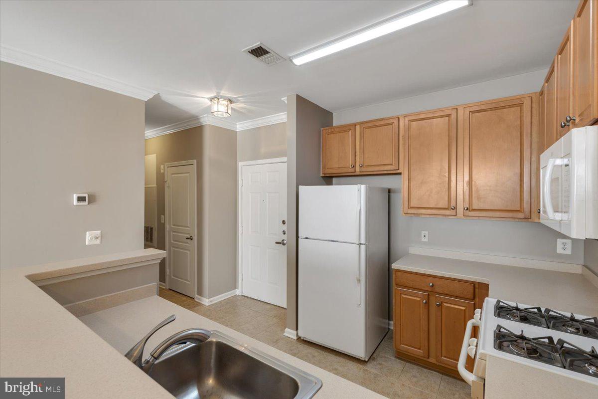 12001 Market Street, Unit 257 Reston, VA 20190 - Photo 5 of 33 a kitchen with a refrigerator sink and cabinets