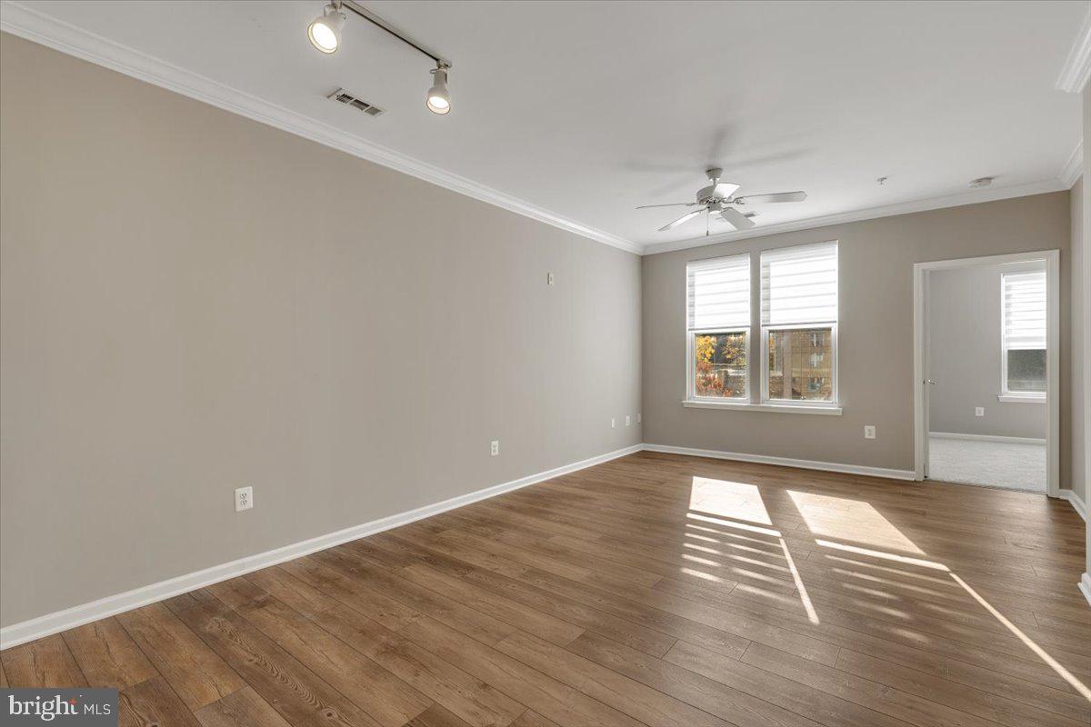 12001 Market Street, Unit 257 Reston, VA 20190 - Photo 7 of 33 an empty room with wooden floor and windows
