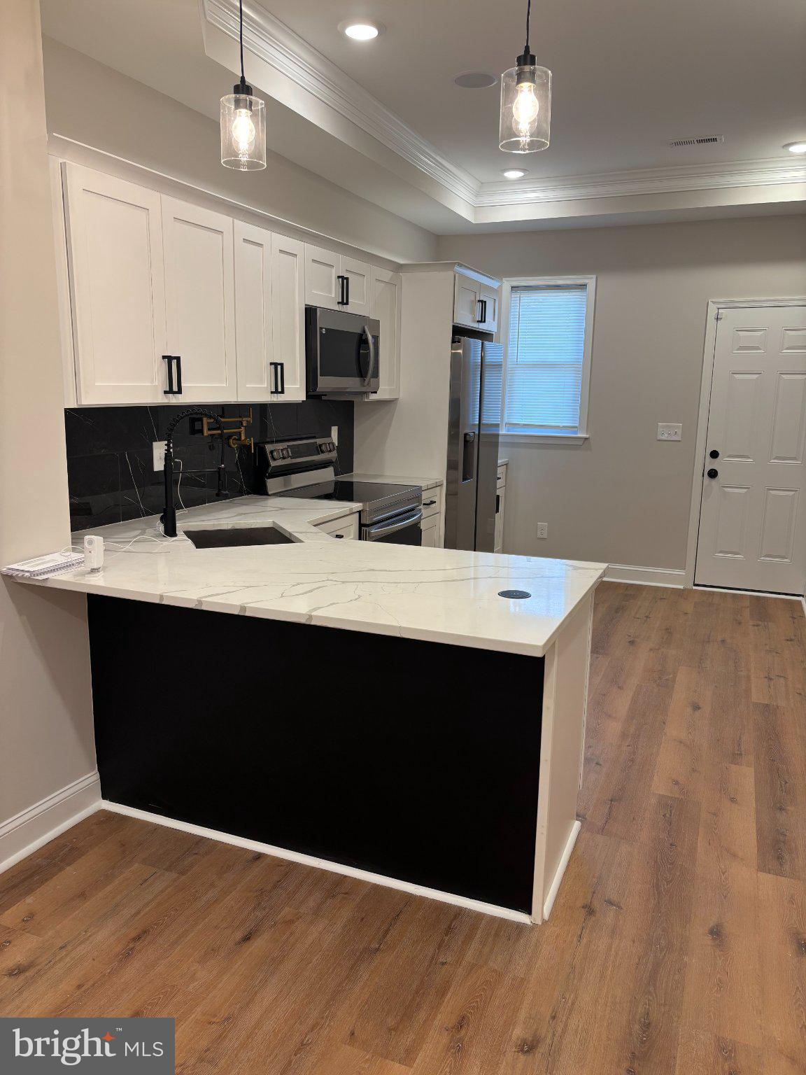 4818 Pimlico Road Baltimore, MD 21215 - Photo 13 of 18 a kitchen with a sink dishwasher a refrigerator and a fireplace