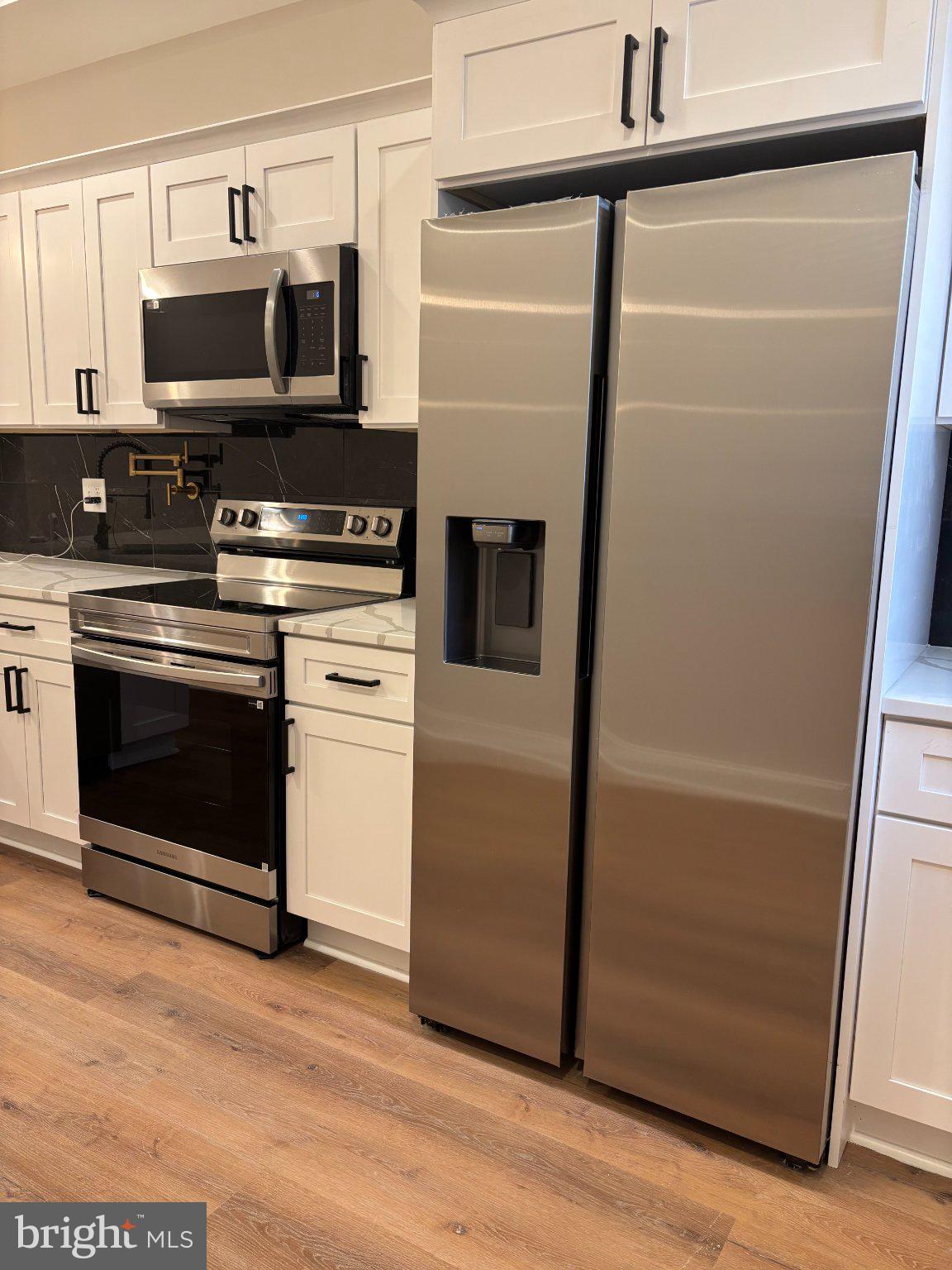 4818 Pimlico Road Baltimore, MD 21215 - Photo 14 of 18 a kitchen with a refrigerator stove and microwave